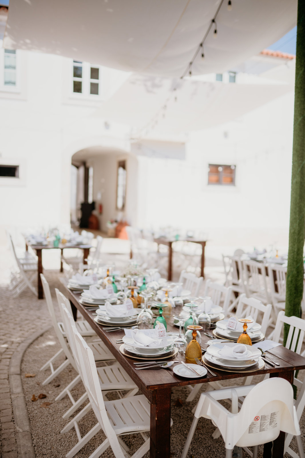 Festa num pátio da quinta com mesas decoradas